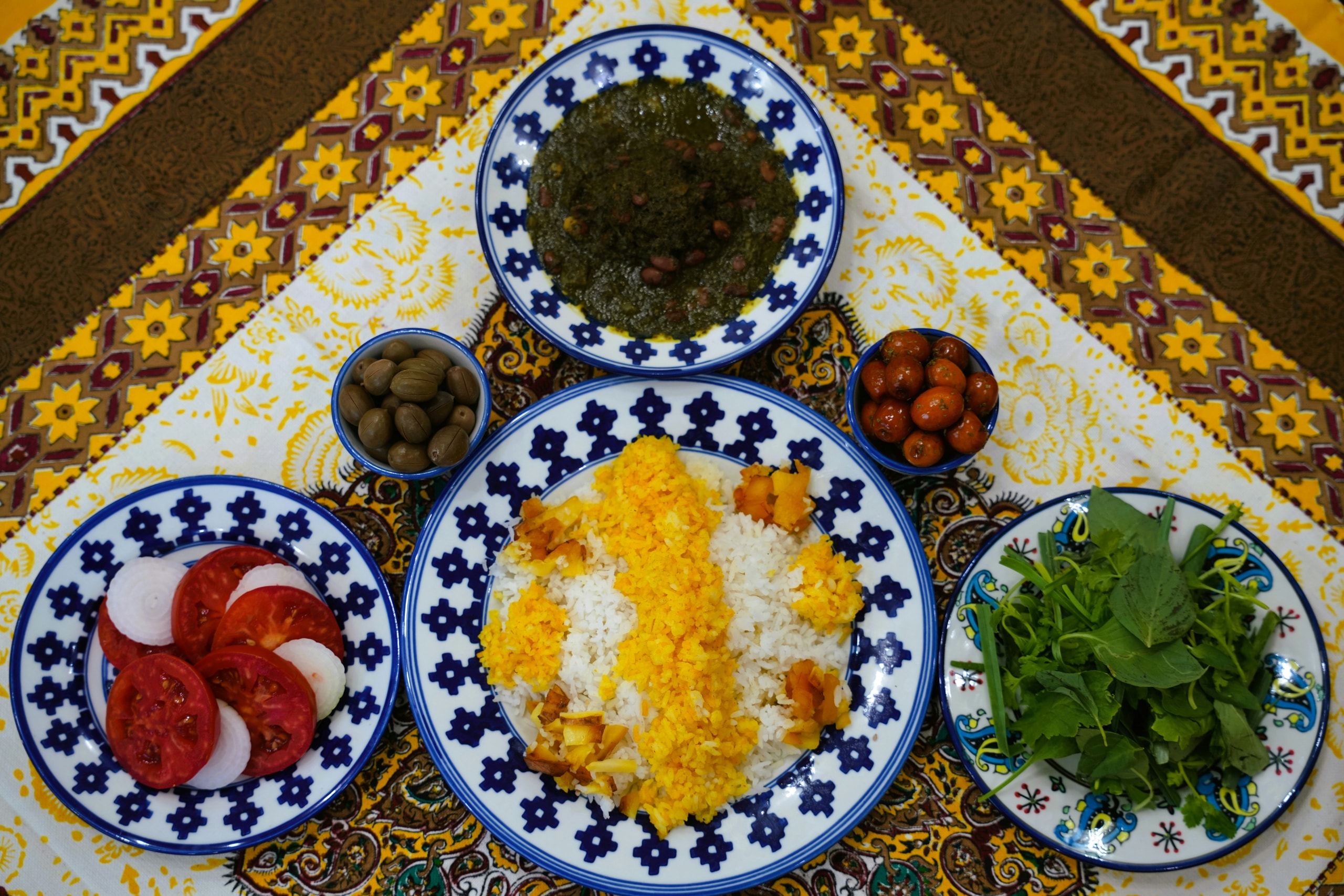 Saffron rice with ghormeh sabzi, fresh herbs and tomatoes